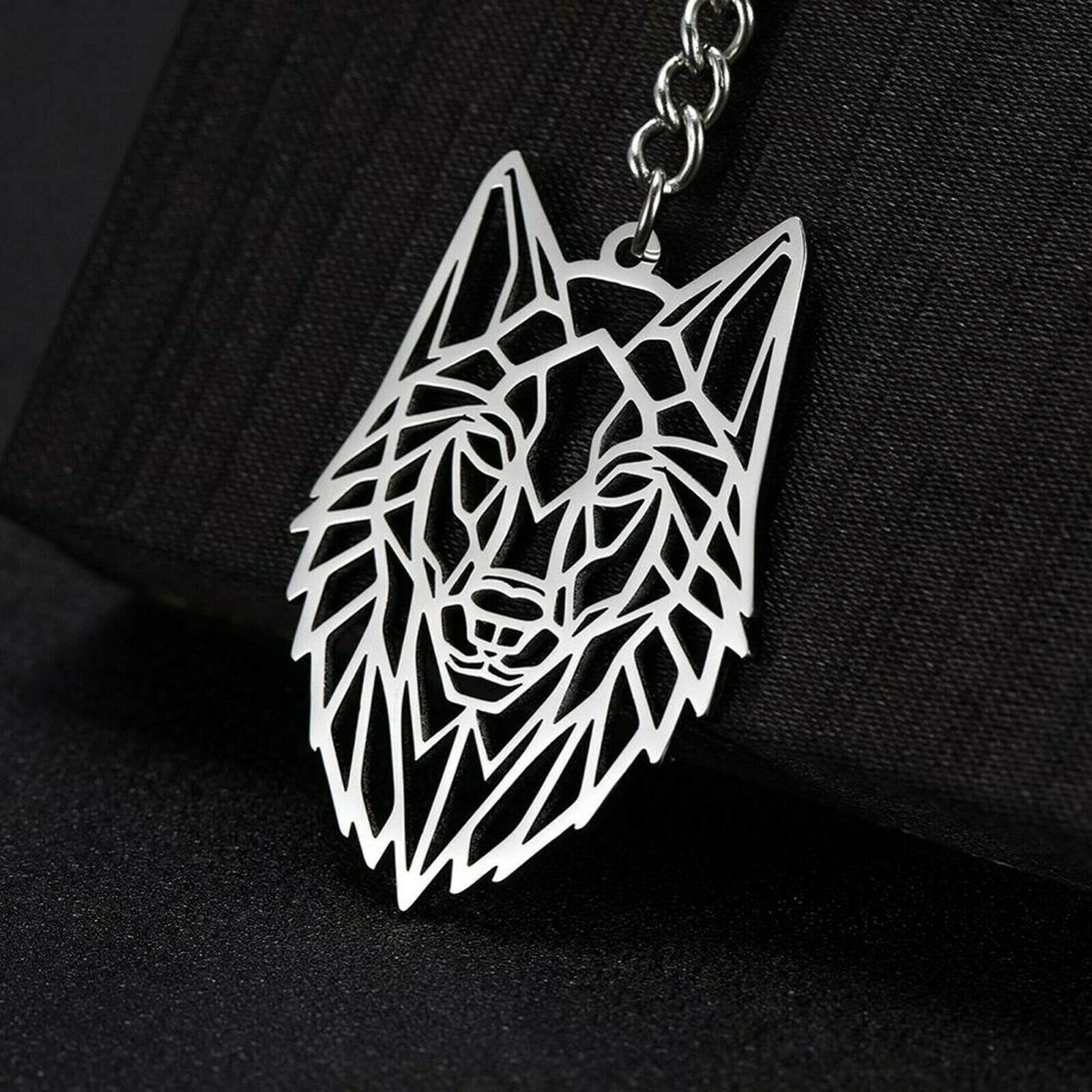 Geometric wolf head keychain on a black background