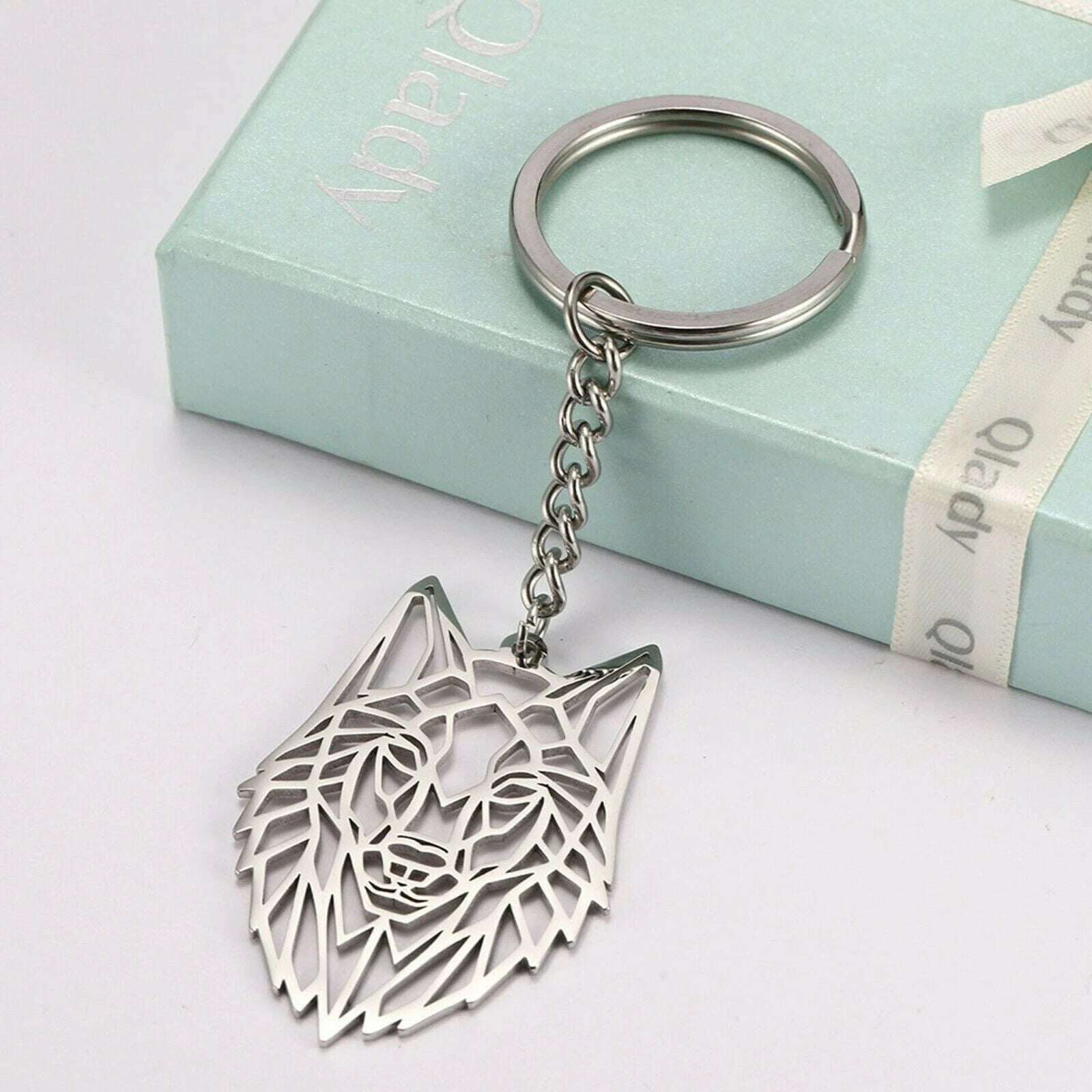 Silver wolf keychain on a light blue box with a white ribbon
