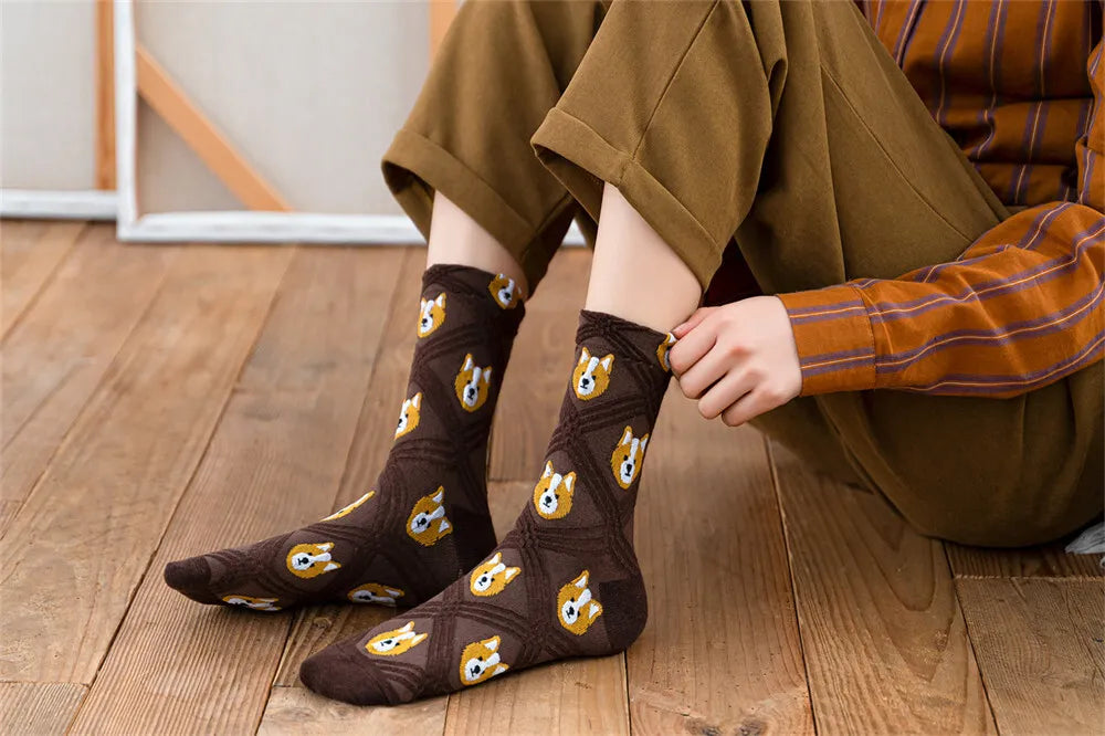 Person wearing brown socks with dog patterns on a wooden floor.
