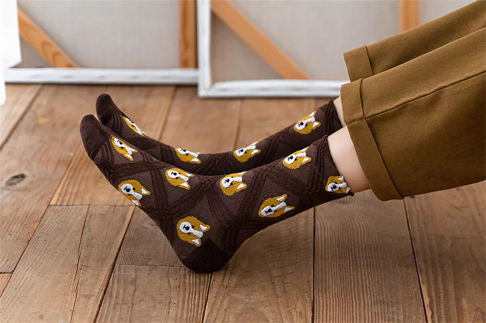 Brown socks with dog pattern worn by a person on a wooden floor.